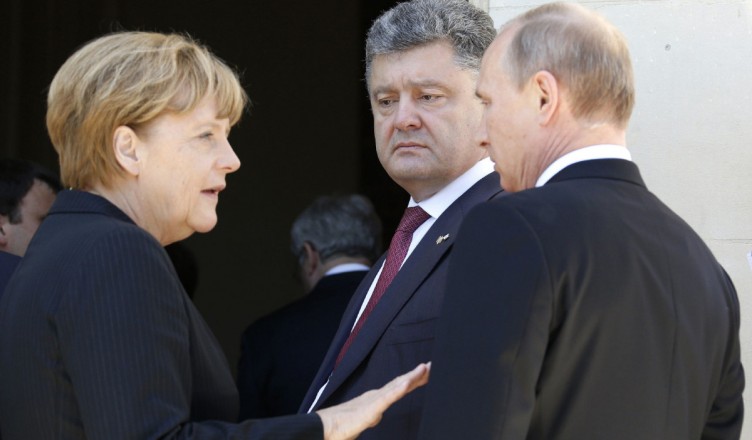 German Chancellor Angela Merkel, left, Russian President Vladimir Putin, right, and Ukrainian president-elect Petro Poroshenko, center, talk after a group photo before a luncheon as they take part in the 70th anniversary of D-Day in Benouville in Normandy, France, Friday, June 6, 2014. World leaders and veterans gathered by the beaches of Normandy on Friday to mark the 70th anniversary of World War Two's D-Day landings. (AP Photo/Regis Duvignau, Pool)