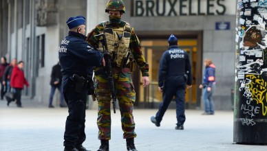 TOPSHOT - A Belgian soldier speaks to a police officer outside Brussels Central Station as people are allowed in small groups of ten to reach the station in order to take their commuter train following attacks in Brussels on March 22, 2016. 
Airlines cancelled hundreds of flights and European railways froze links with Brussels after a series of bombs blasts killed around 35 people in the city's airport and a metro train, sparking a broad security response. / AFP / EMMANUEL DUNAND        (Photo credit should read EMMANUEL DUNAND/AFP/Getty Images)
