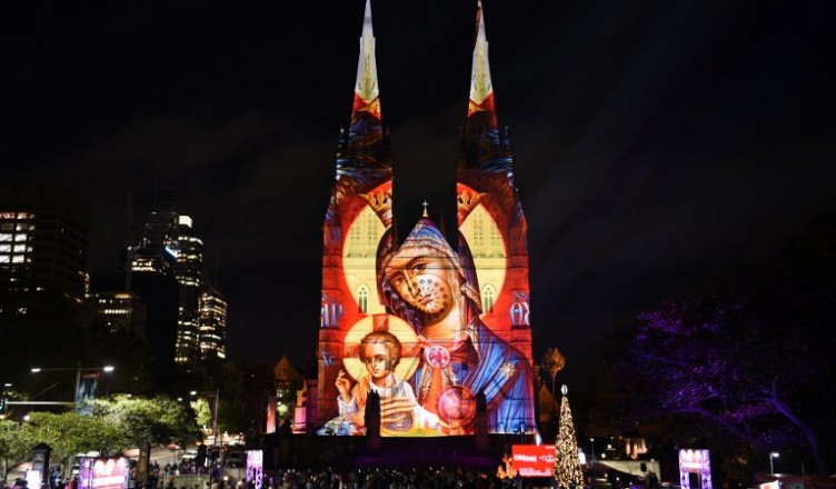 St Mary's Cathedral is illuminated with a Christmas-themed projection in Sydney to celebrate the Christmas season on December 9, 2016. / AFP PHOTO / SAEED KHAN