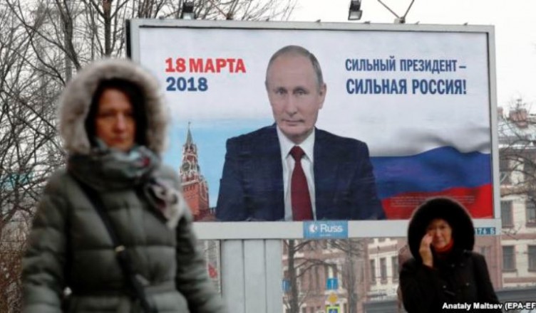 epa06433588 People walk past an election poster reading 'Strong President Strong Russia' in support of Russian President Vladimir Putin, a self-nominated candidate in the upcoming presidential election on the Moscowsky prospect in St.Petersburg, Russia, 12 January 2018. Presidential elections in Russia is scheduled for 18 March 2018.  EPA-EFE/ANATOLY MALTSEV