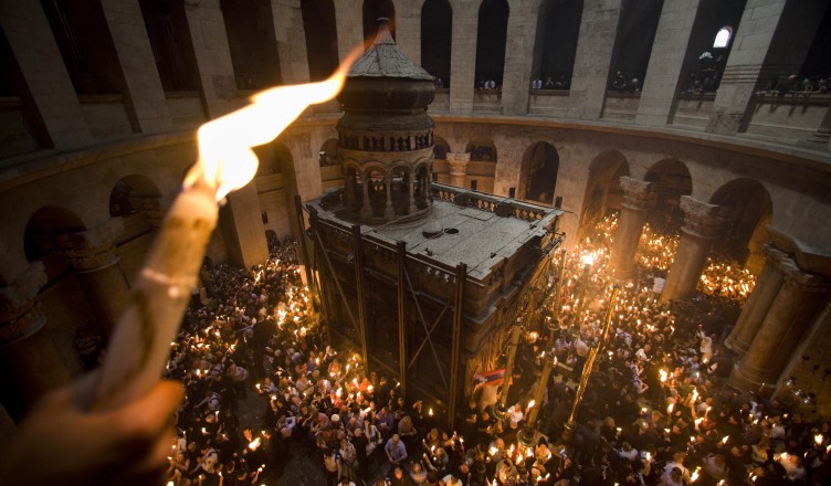 FILE - In this April 3, 2010 file photo Orthodox Christian pilgrims hold candles at the Church of the Holy Sepulcher, traditionally believed to be the site of the crucifixion of Jesus Christ, during the Holy Fire ceremony, in Jerusalem's Old City. Thousands of Christian believers will fill the medieval chambers of the Church of the Holy Sepulcher in Jerusalem on Saturday April 23, 2011 for a yearly ritual known as the Holy Fire, packed shoulder to shoulder and holding burning candles as pilgrims have done for centuries. And in 2011, as in centuries past, the church will have only one door and no fire exit.(AP Photo/Bernat Armangue, File)