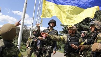 In this photo taken on Saturday, July  5, 2014, Ukrainian soldiers and Ukrainian Defense Minister Valery Heletey, third from right, raise a Ukrainian flag in downtown Slovyansk, eastern Ukraine. After Ukrainian forces' seizure of a key rebel stronghold in the east, the major cities of Donetsk and Luhansk could be the next focus of major fighting. Three bridges on roads leading to Donetsk were blown up Monday  possibly to hinder military movements, though the rebels claim it was the work of pro-Kiev saboteurs. (AP Photo/str)