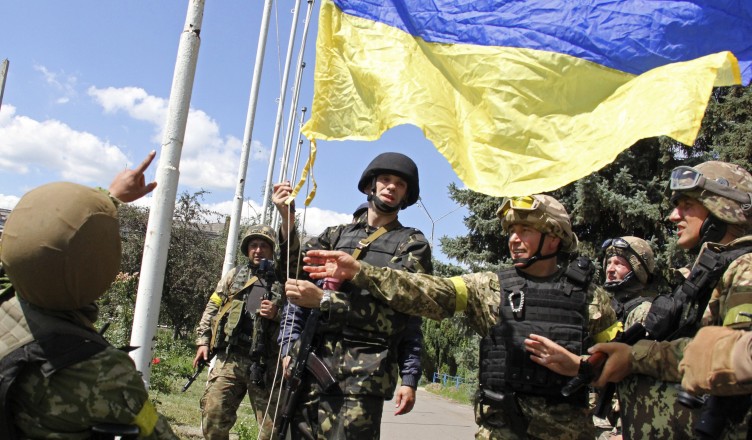 In this photo taken on Saturday, July  5, 2014, Ukrainian soldiers and Ukrainian Defense Minister Valery Heletey, third from right, raise a Ukrainian flag in downtown Slovyansk, eastern Ukraine. After Ukrainian forces' seizure of a key rebel stronghold in the east, the major cities of Donetsk and Luhansk could be the next focus of major fighting. Three bridges on roads leading to Donetsk were blown up Monday  possibly to hinder military movements, though the rebels claim it was the work of pro-Kiev saboteurs. (AP Photo/str)