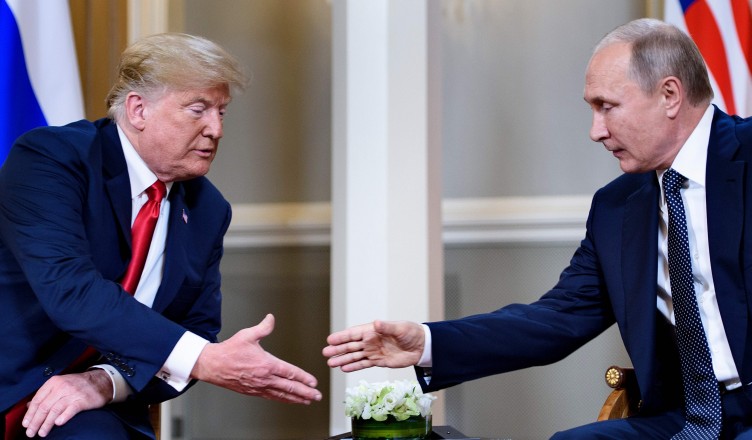US President Donald Trump (L) and Russian President Vladimir Putin reach to shake hands before a meeting in Helsinki, on July 16, 2018. / AFP PHOTO / Brendan SmialowskiBRENDAN SMIALOWSKI/AFP/Getty Images ORIG FILE ID: AFP_17Q13H