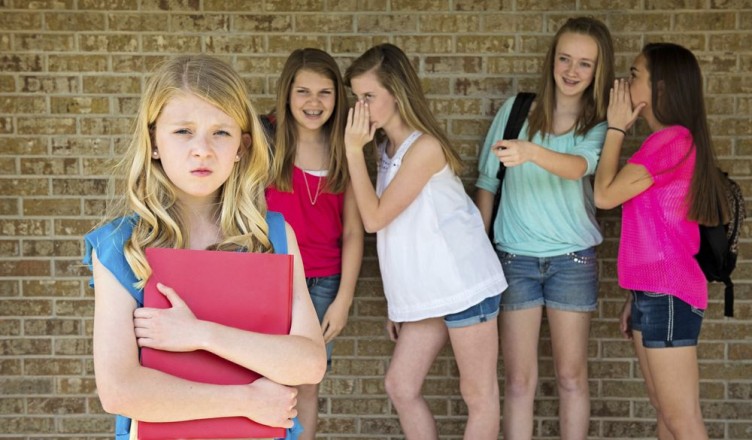 Pre-teen girl being bullied by a group of mean girls.