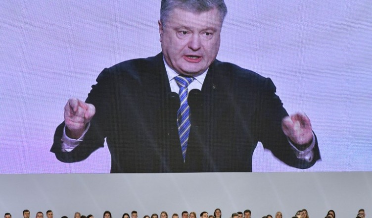 Ukrainian President Petro Poroshenko is seen on a giant screen while he gives a speech during a meeting with his supporters in Kiev on January 29, 2019. - Ukrainian President Petro Poroshenko on January 29, launched an uphill battle for re-election, five years on from a bloody uprising that brought him to power on a promise to tackle corruption. (Photo by Genya SAVILOV / AFP)
