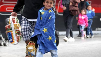 MUNICH, GERMANY - SEPTEMBER 05:  A migrant boy covered in a EU flag arrives from Austia at Munich Hauptbahnhof main railway station on September 5, 2015 in Munich, Germany. Thousands of migrants are traveling to Germany following an arduous ordeal in Hungary that resulted in thousands walking on foot and then being bussed by Hungarian authorities from Budapest to the Austrian-Hungarian border.  (Photo by Alexandra Beier/Getty Images)