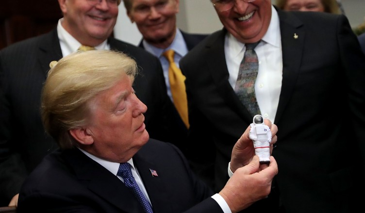 WASHINGTON, DC - DECEMBER 11:  AFP OUT  U.S. President Donald Trump holds a plastic astronaut figurine given to him by Apollo 17 astronaut and former U.S. Senator Jack Schmitt during a signing ceremony for 'Space Policy Directive 1' in the Roosevelt Room at the White House December 11, 2017 in Washington, DC. On the 45th anniversary of Apollo 17 -- the last crewed mission to the moon -- Trump signed the order directing NASA 'to lead an innovative space exploration program to send American astronauts back to the Moon, and eventually Mars,' according White House spokesman Hogan Gidley.  (Photo by Chip Somodevilla/Getty Images)