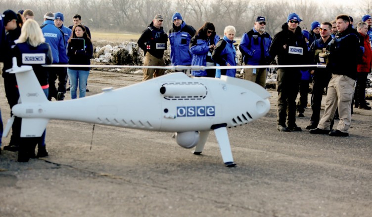 Members of the Organization for Security and Co-operation in Europe (OSCE) Observer Mission, Special Monitoring Mission in Ukraine, arrive for the test flight of the unmanned aerial vehicle Camcopter S-100? along the eastern front line near Ukraine's village of Stepanivka in the Donetsk region, about thirty kilometers from the front line between pro-Russian separatists and the Ukrainian army on March 28, 2018. (Photo by Aleksey FILIPPOV / AFP)