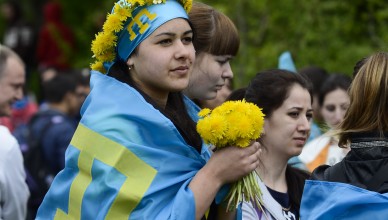 Crimean Tatars, with Crimean Tatars blue flags on, take part in climbing the Chatyr-Dag mountains to commemorate the 71st anniversary of Soviet dictator Stalin's mass deportation of Crimean Tatars, near Alushta, Crimea, Saturday, May 16, 2015. Young Tatars with the Crimean Tatars blue flags made the ascent of the Chatyr-Dag mounts massif  to honor the victims of the 1944 deportation of Crimean Tatars.  (AP Photo/Anton Volk)