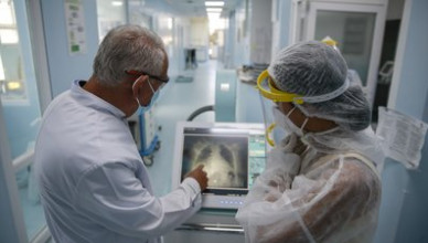 Dr. Shemsedin Dreshaj, left, head of the ICU unit looks at the X-Ray of the lungs of a patient with COVID-19 in the Clinic for Infectious Diseases in Pristina, Kosovo, Monday, Sept. 21, 2020. (AP Photo/Visar Kryeziu)