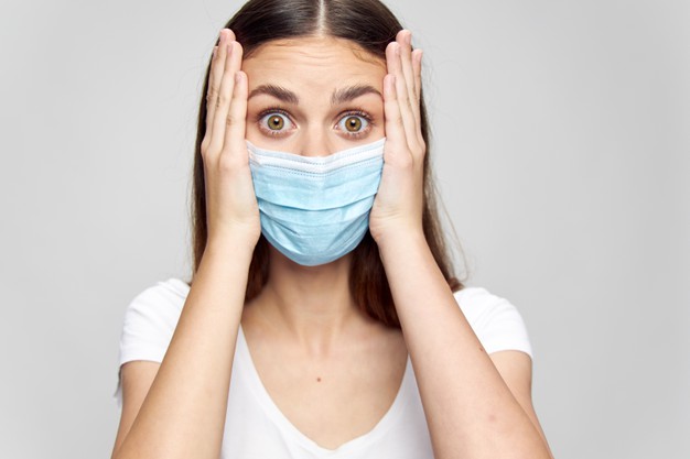 surprised-woman-in-medical-mask-touching-face-with-hands_163305-32091