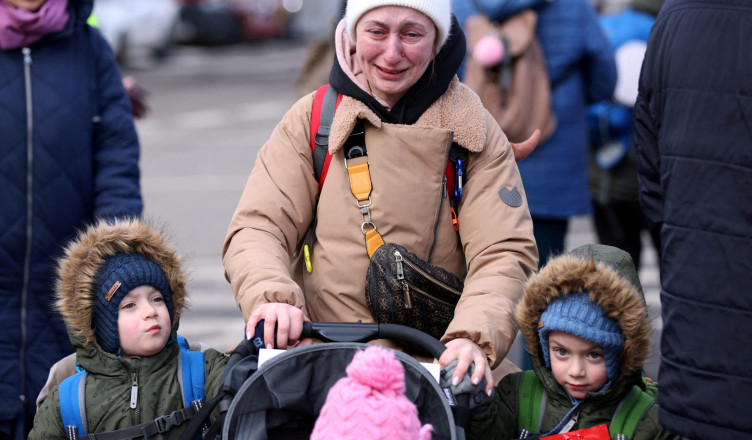 A woman cries next to her children after fleeing from Russia's invasion of Ukraine, at the border crossing in Siret, Romania, February 28, 2022. REUTERS/Stoyan Nenov     TPX IMAGES OF THE DAY
