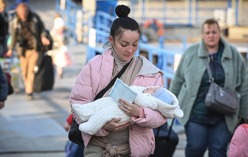 A refugee from Ukraine holds her child after arriving by ferry at the Romanian-Ukrainian border point Isaccea-Orlivka on March 24, 2022. (Photo by Daniel MIHAILESCU / AFP) (Photo by DANIEL MIHAILESCU/AFP via Getty Images)