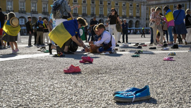 LISBON, PORTUGAL - JUNE 04: Ukrainians light candles during an action in which two hundred and forty pairs of children's shoes were on display in Praça do Comercio in memory of the prematurely killed Ukrainian children while demonstrators ask people to sign an electronic petition stating "Let's help stop the murders, crimes and atrocities committed by Russian soldiers against children in Ukraine," during "#SaveUkrainianChildren" civil action on June 04, 2022, in Lisbon, Portugal. Students from Ukrainian schools in Lisbon read poems and sung songs in support of Ukrainian children during the action. The aim of this international event, taking place in several cities, is to draw the attention of the international community, citizens and rulers to the plight of thousands of children in Ukraine. (Photo by Horacio Villalobos#Corbis/Corbis via Getty Images)