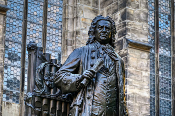 Close-up of the historical monument of the famous Baroque composer in the city center of Leipzig, created  in 1907 by Carl Seffner (1861-1932); in the background the St. Thomas Church