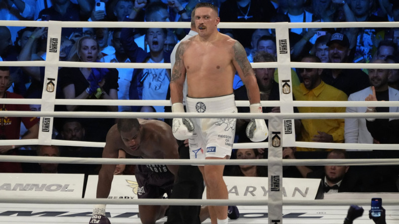 Ukraine's Oleksandr Usyk waits as Britain's Daniel Dubois takes a knee during their world heavyweight title fight at Tarczynski Arena in Wroclaw, Poland, Sunday, Aug. 27, 2023. Oleksandr Usyk defends his WBC, IBF and WBA heavyweight titles for the first time in a year when he faces hard-hitting British challenger Daniel Dubois in a clash of styles. (AP Photo/Czarek Sokolowski)