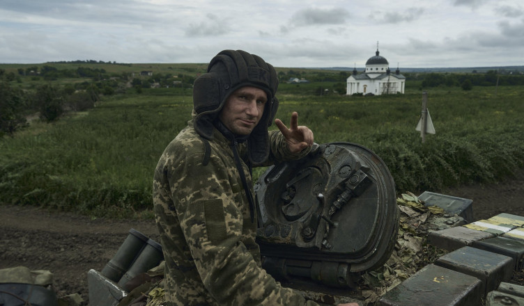 A Ukrainian soldier shows a victory sign atop a tank at the frontline near Bakhmut, Donetsk region, Ukraine, Saturday, June 17, 2023. (AP Photo/Libkos)
