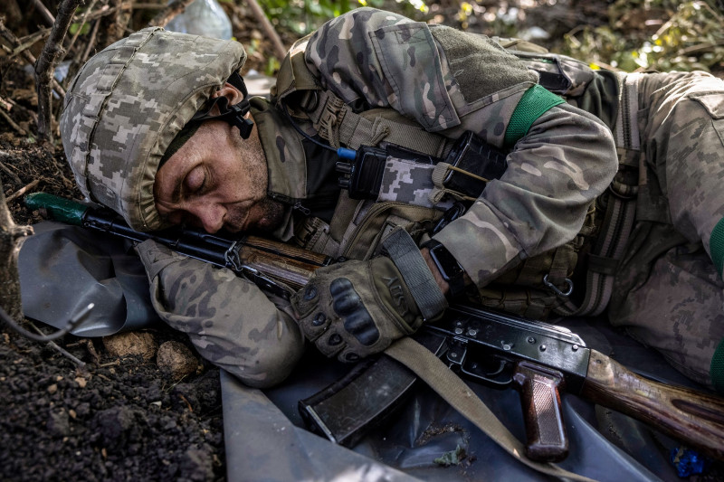 LUHANSK REGION, UKRAINE-SEPTEMBER 1: An exhausted Ukrainian soldier named Valentyn sleeps with his weapon on the ground after rotating out from a trench position as Ukrainian and Russian forces traded artillery volleys southeast of Kupyansk.(Heidi Levine for The Washington Post via Getty Images).