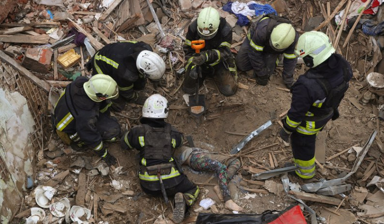 Emergency workers retrieve the body of a 10-year old boy who was killed in a Russian air attack that hit a multi-storey building in central Kharkiv, Friday, Oct. 6, 2023. (AP Photo/Alex Babenko)
