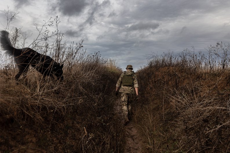 DONETSK OBLAST, UKRAINE - NOVEMBER 6: Ukrainian soldier walks with a dog through a trench on the frontline as the Russia-Ukraine war continues in Niu York, Ukraine on November 6, 2023. (Photo by Diego Herrera Carcedo/Anadolu via Getty Images)
