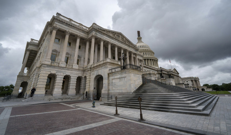 Storm clouds pass over the House of Representatives, foreground, side of the U.S. Capitol in Washington, Sunday, Sept. 24, 2023. Congress will return this week to continue debating a temporary funding bill to keep the government open and running. (AP Photo/J. David Ake)