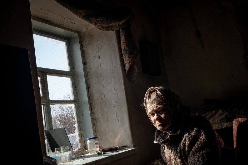OCHERETYNE, UKRAINE - MARCH 04: Paraskovia, 73, sits in a chair as "White Angel" police officers attempt unsuccessfully to convince her family to evacuate the frontline town of Ocheretyne, Ukraine on March 04, 2024. (Photo by Wolfgang Schwan/Anadolu via Getty Images)
