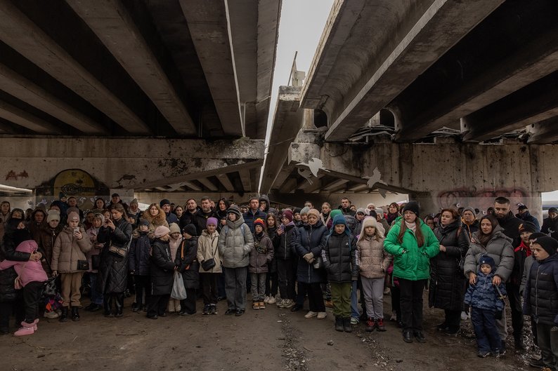 TOPSHOT - Local residents attend a memorial ceremony under a destroyed bridge in Irpin, northwest of Kyiv, on February 24, 2024, on the second anniversary of Russia's invasion of Ukraine. (Photo by Roman PILIPEY / AFP) (Photo by ROMAN PILIPEY/AFP via Getty Images)