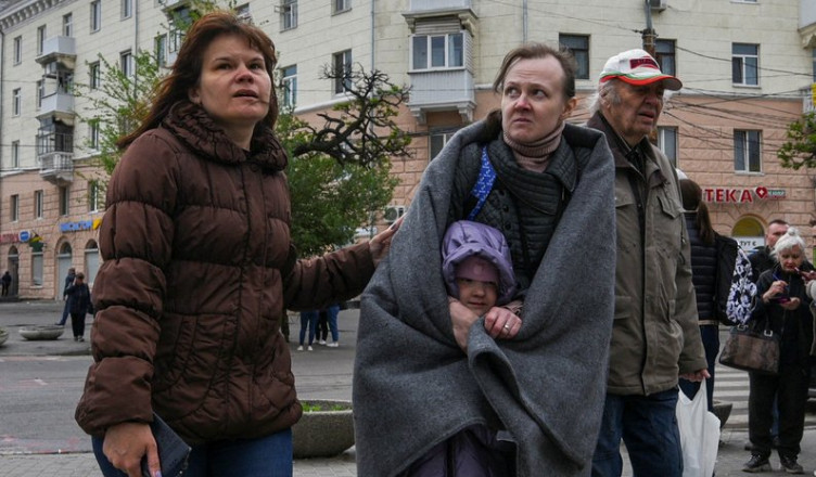 Local residents stand at a site of an apartment building hit by a Russian missile strike, amid Russia's attack on Ukraine, in Dnipro, Ukraine April 19, 2024. REUTERS/Mykola Synelnykov