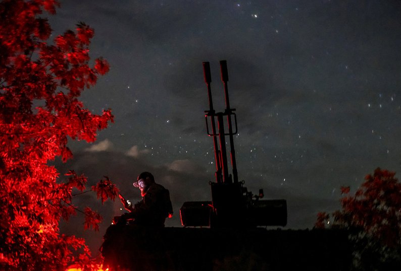 A Ukrainian serviceman from an anti-drone mobile air defence unit uses his mobile device near a ZU-23-2 anti aircraft cannon as he waits for Russian kamikaze drones, amid Russia's attack on Ukraine, in Kherson region, Ukraine June 11, 2024. REUTERS/Ivan Antypenko     TPX IMAGES OF THE DAY