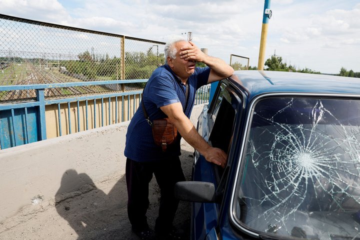A man reacts next to a damaged car at a site of a Russian missile strike, amid Russia's attack on Ukraine, in Pokrovsk, Donetsk region Ukraine June 24, 2024. REUTERS/Alina Smutko     TPX IMAGES OF THE DAY