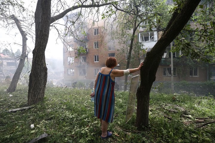 TOPSHOT - A local resident stands next to a residential building damaged as a result of a missile attack in Kyiv on July 8, 2024. Russia launched more than 40 missiles at several cities across Ukraine on July 8, 2024 in an attack that killed at least 20 people people and smashed into a children's hospital in Kyiv, officials said. (Photo by Anatolii STEPANOV / AFP) (Photo by ANATOLII STEPANOV/AFP via Getty Images)