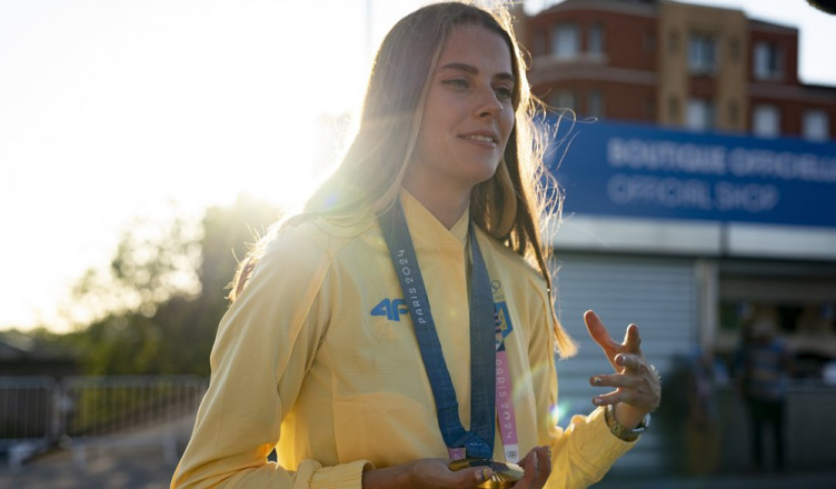 Ukrainian high jumper Yaroslava Mahuchikh holds her gold medal while speaking to journalists in Paris, France, Sunday, Aug. 5, 2024. (AP Photo/Hanna Arhirova)