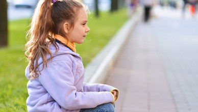 Beautiful,Little,Girl,In,Jacket,Sitting,On,Paving-stone,Curb,Profile,