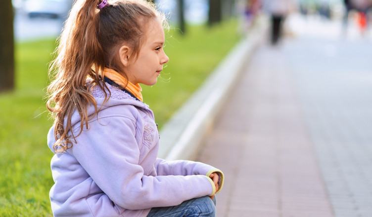 Beautiful,Little,Girl,In,Jacket,Sitting,On,Paving-stone,Curb,Profile,