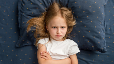 Angry,Child,Girl,Lying,On,The,Bed,With,Crossed,Hands