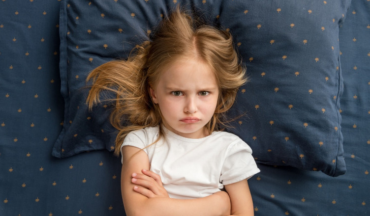 Angry,Child,Girl,Lying,On,The,Bed,With,Crossed,Hands
