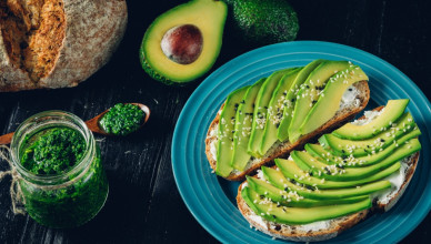 Fresh green Avocado sandwich on dark rye bread made with fresh sliced avocados from above. Avo toast, avo sandwich, vegan and vegetarian