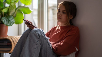 Upset,Anxious,Teen,Girl,Reads,Message,In,Smartphone,Sits,On