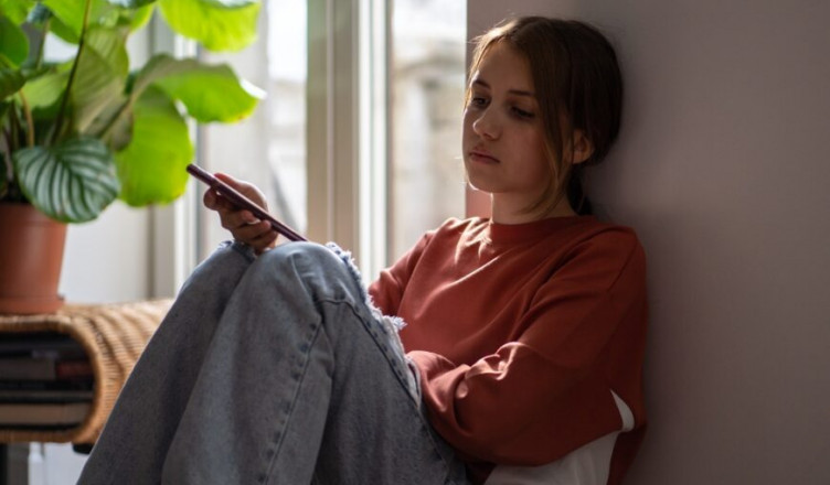 Upset,Anxious,Teen,Girl,Reads,Message,In,Smartphone,Sits,On